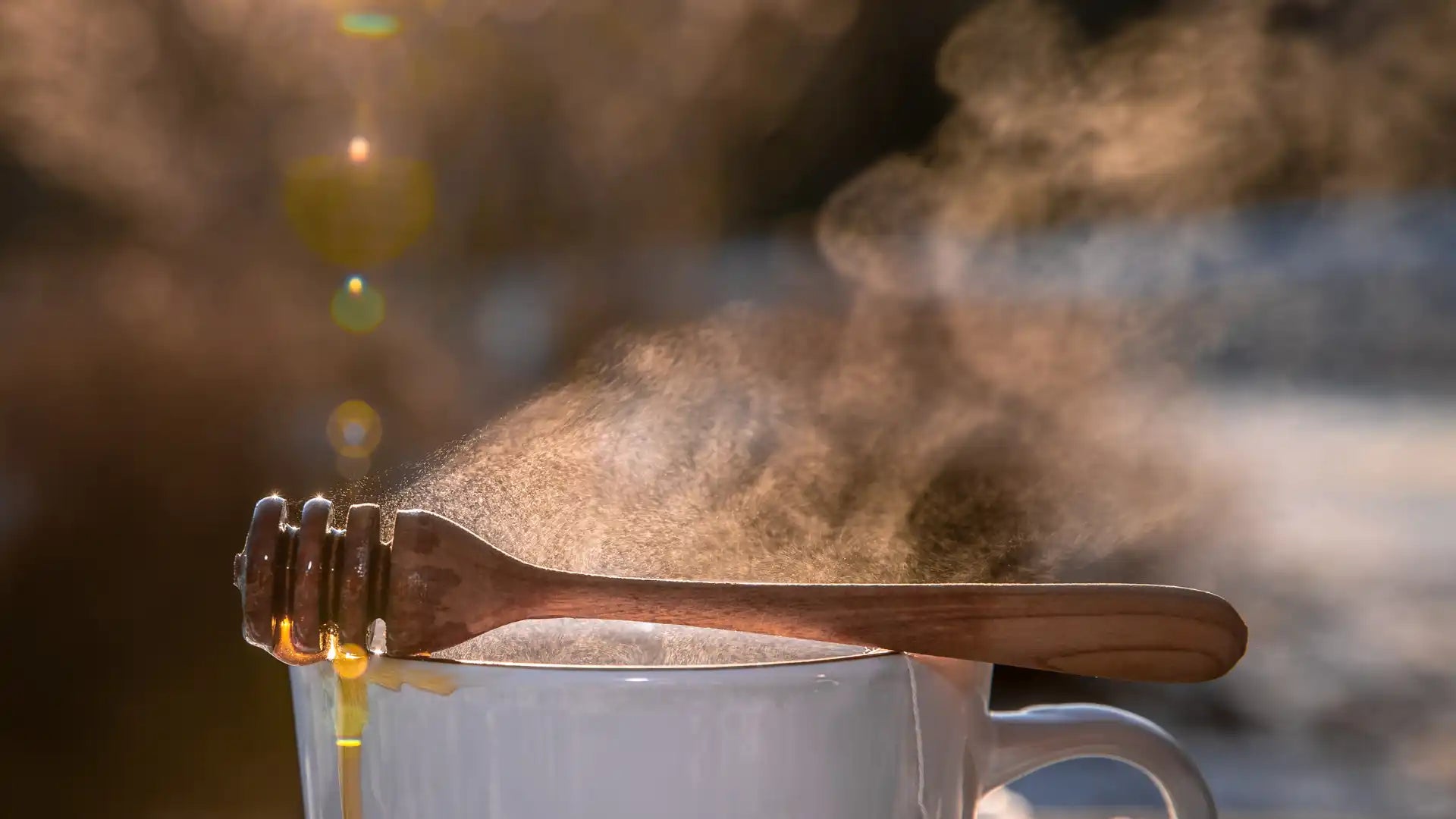 Puinen hunajakauha kaarevalla kahvalla ja metallikulholla, jossa on luonnollinen puun syykuvio.